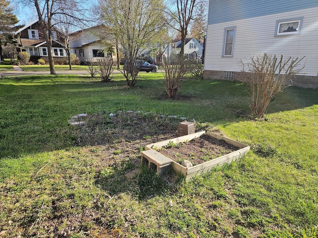 view of green lawn featuring a vegetable garden
