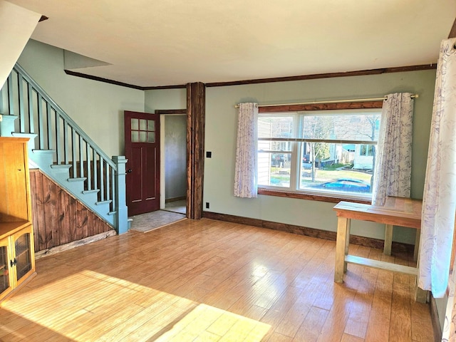 entryway featuring wood finished floors, crown molding, stairway, and baseboards