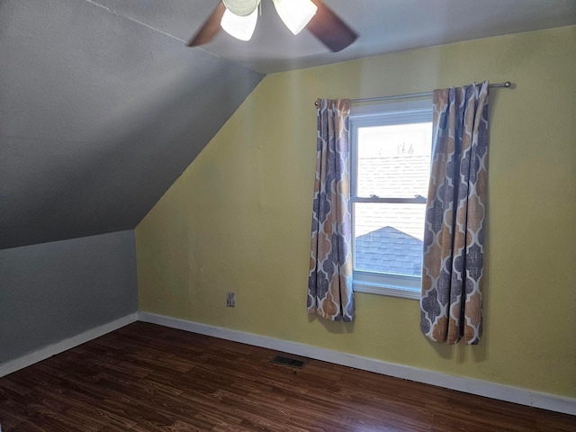 additional living space with wood finished floors, vaulted ceiling, a ceiling fan, and baseboards