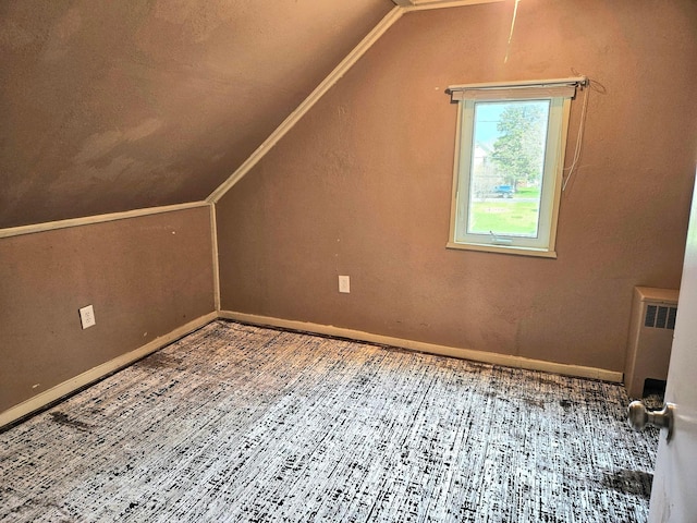 additional living space featuring vaulted ceiling, radiator heating unit, wood finished floors, and baseboards