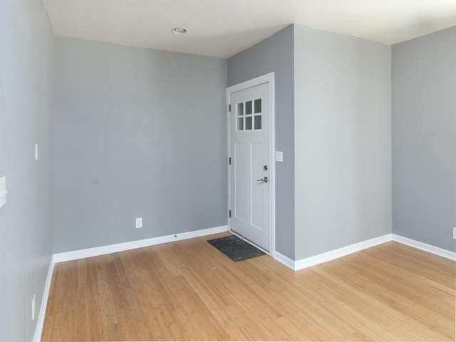 spare room featuring light wood-type flooring and baseboards