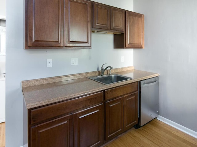 kitchen with a sink, dishwasher, light wood-type flooring, and dark brown cabinetry