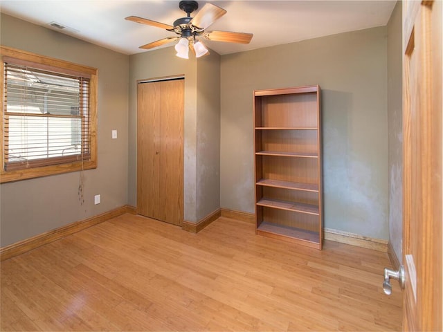 unfurnished bedroom with light wood finished floors, baseboards, a closet, and ceiling fan