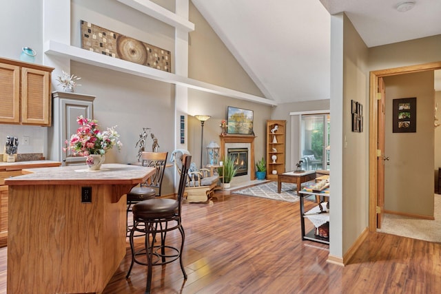 5662 Donegal Dr, Shoreview, MN 55126 - kitchen featuring wood finished floors, a center island, a kitchen breakfast bar, open floor plan, and light countertops