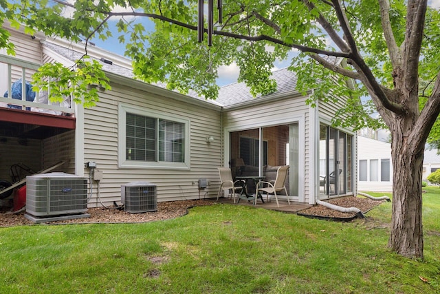 5662 Donegal Dr, Shoreview, MN 55126 - rear view of house featuring a yard, roof with shingles, a sunroom, and a patio
