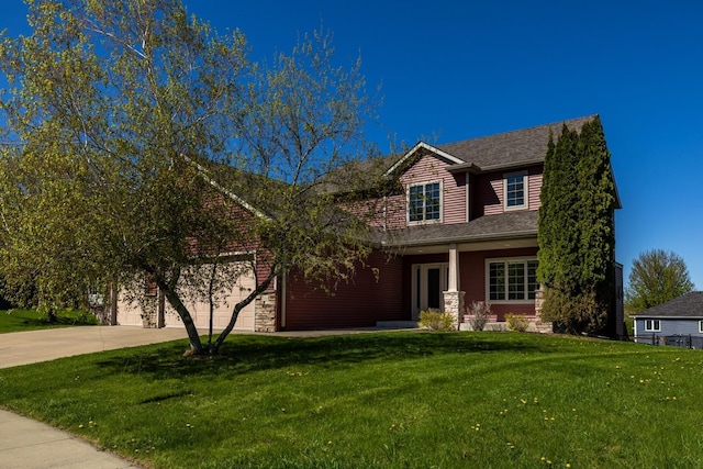 view of front facade with concrete driveway, an attached garage, and a front yard