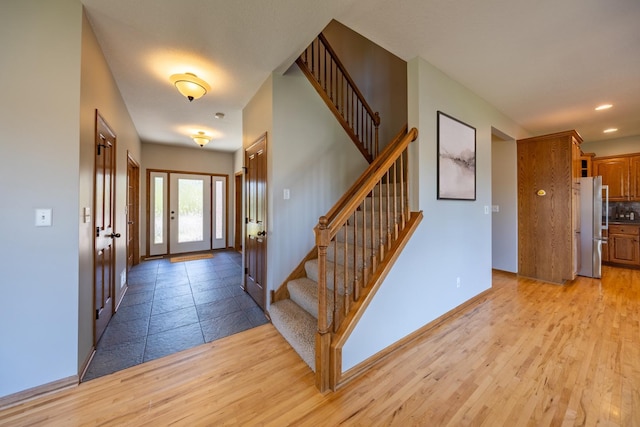 entryway with stairs, light wood-style floors, baseboards, and recessed lighting