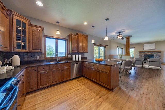 kitchen with stainless steel appliances, a sink, brown cabinetry, light wood-style floors, and recessed lighting