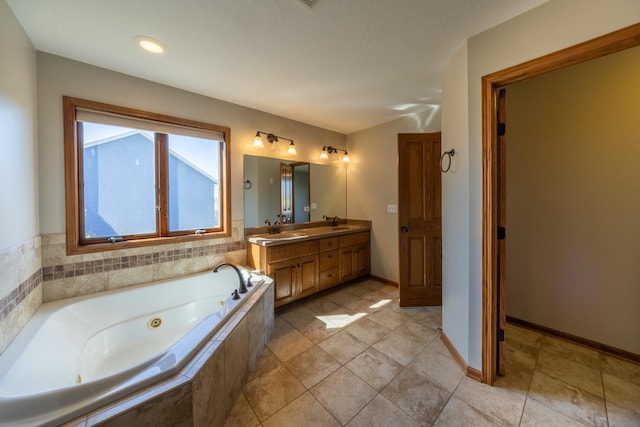 full bathroom with a whirlpool tub, double vanity, and baseboards