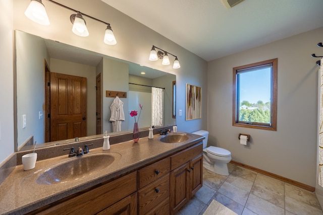 bathroom featuring toilet, baseboards, double vanity, and a shower with shower curtain
