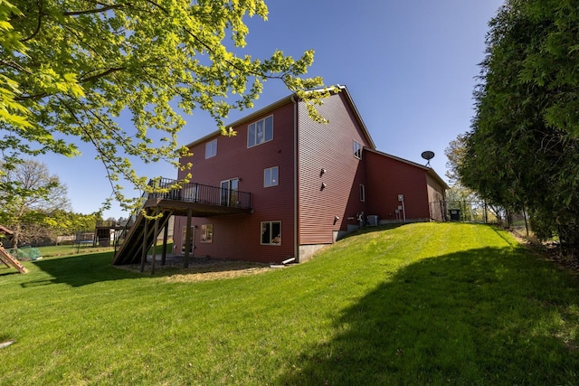 rear view of house with a wooden deck and cooling unit