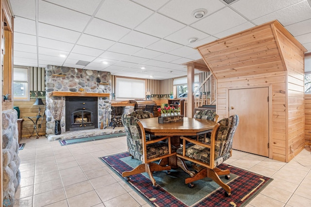 24295 Matson Point Trl, Lida Twp, MN 56572 - dining room with light tile patterned floors, a paneled ceiling, wooden walls, stairway, and a stone fireplace