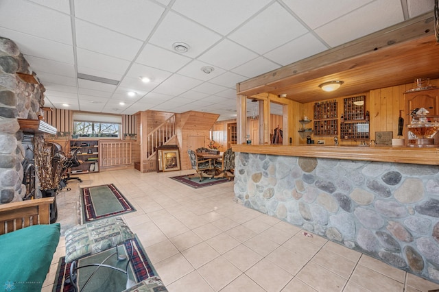 24295 Matson Point Trl, Lida Twp, MN 56572 - tiled living area featuring stairway, wooden walls, a paneled ceiling, and a fireplace