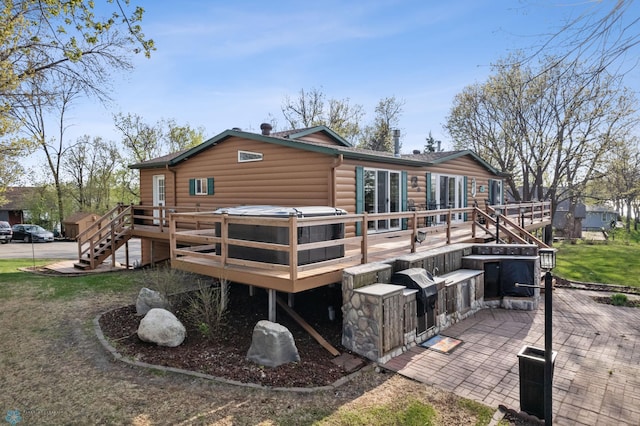 24295 Matson Point Trl, Lida Twp, MN 56572 - back of house featuring a deck, faux log siding, stairway, a hot tub, and a patio