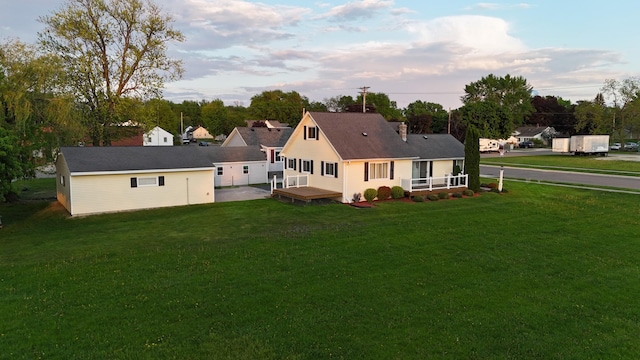 back of property with a deck and a lawn