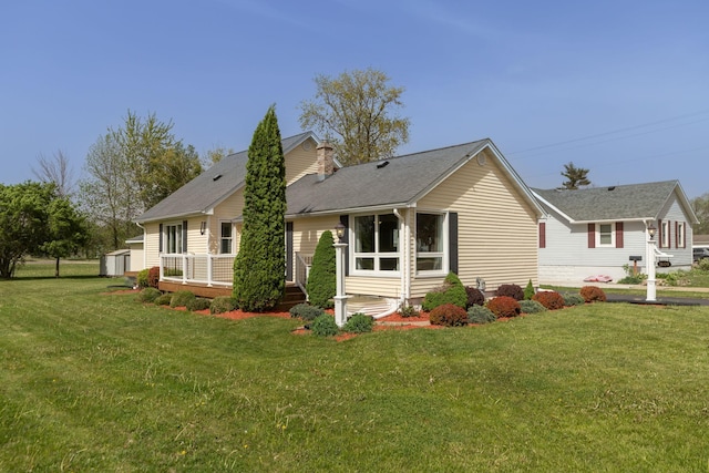 back of house featuring a storage shed, an outbuilding, and a yard