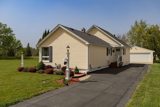 view of side of home featuring an outbuilding, a detached garage, a lawn, crawl space, and entry steps