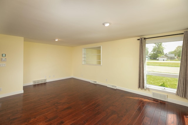 unfurnished room featuring dark wood-style flooring, baseboards, and recessed lighting