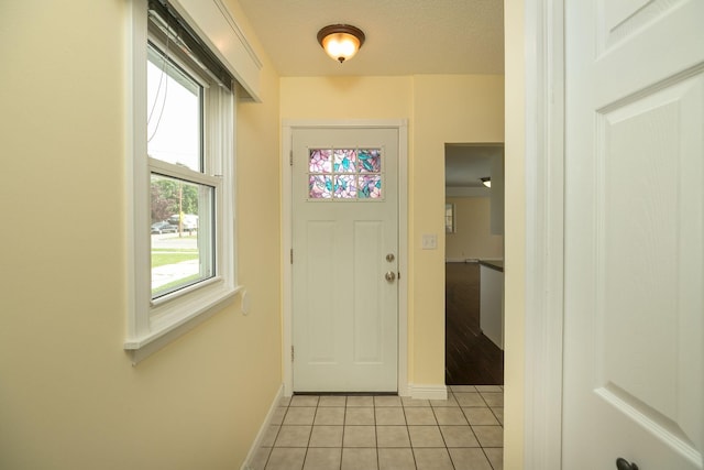 entryway featuring light tile patterned flooring and baseboards