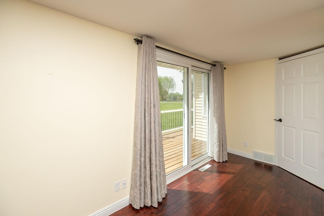 unfurnished room with dark wood-style floors and baseboards