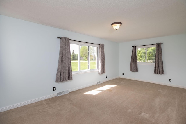 carpeted empty room featuring plenty of natural light and baseboards