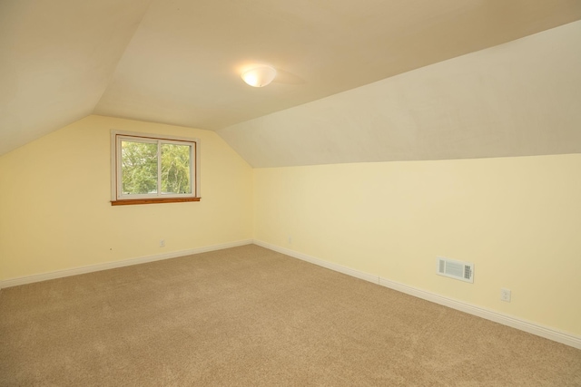 bonus room with light colored carpet, vaulted ceiling, and baseboards
