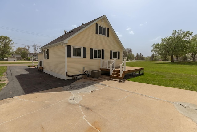 back of house with a yard, a deck, and central AC unit