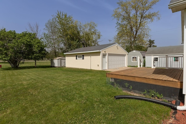 view of green lawn featuring an outdoor structure, a garage, a shed, and a deck