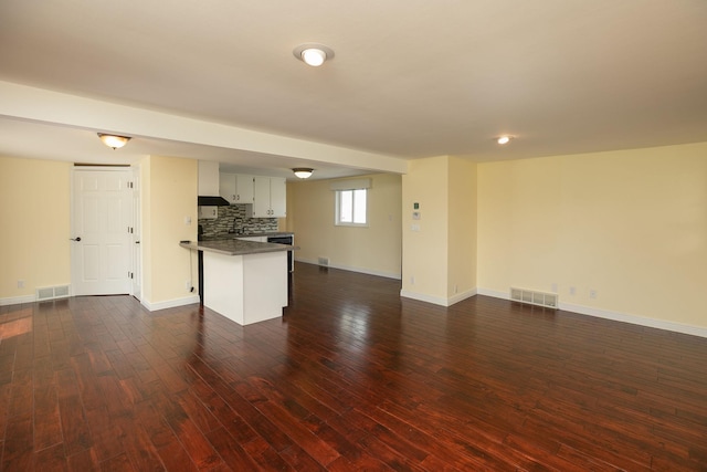 1609 1st Ave NE, Austin, MN 55912 - unfurnished living room featuring dark wood-style floors, baseboards, and a sink