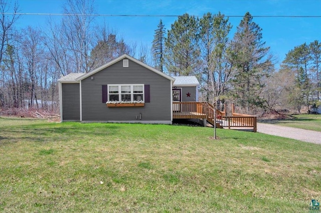 view of front of home featuring a wooden deck and a front lawn