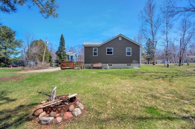 view of home's exterior with a wooden deck and a yard