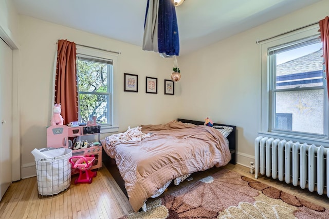 bedroom featuring radiator and hardwood / wood-style flooring