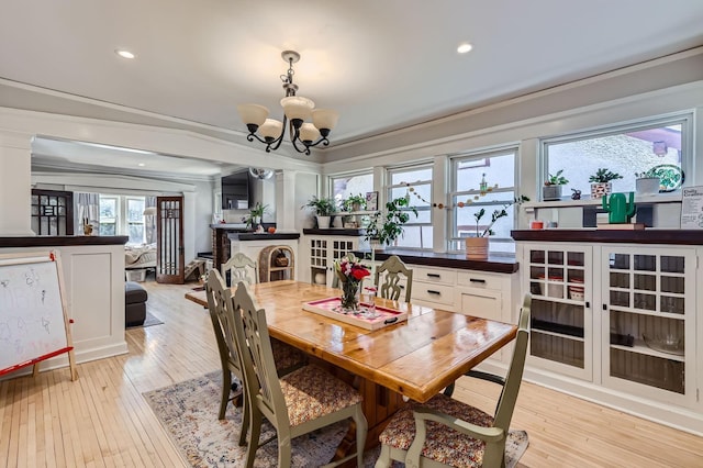 dining area with a chandelier, light wood-style floors, ornamental molding, and recessed lighting