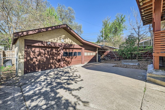 view of side of home featuring a garage and fence