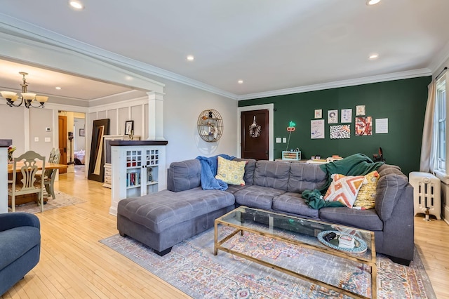 living area featuring a chandelier, radiator heating unit, light wood finished floors, recessed lighting, and crown molding