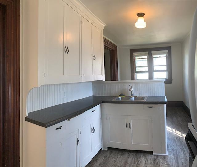 504 Buchanan St, Red Wing, MN 55066 - kitchen featuring a sink, dark countertops, white cabinets, and a peninsula