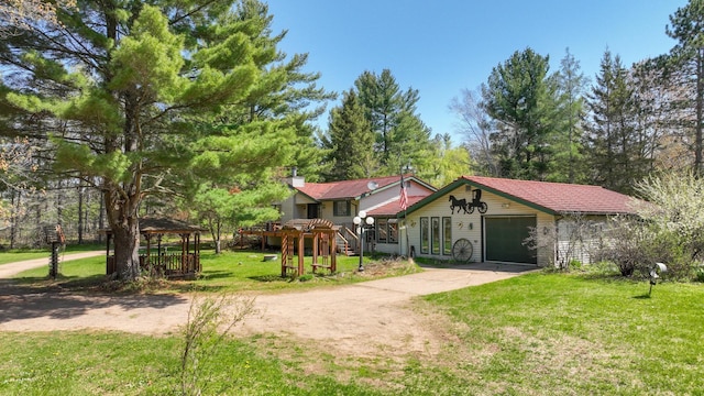 view of front of property with concrete driveway, a front lawn, and a gazebo