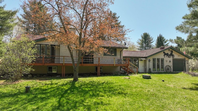 rear view of house with a lawn, stairs, and a wooden deck