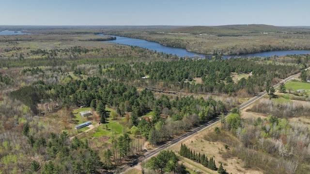 aerial view of property's location featuring a large body of water and a forest