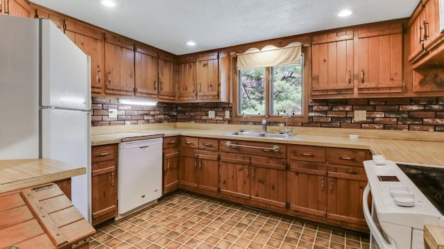 kitchen with white appliances, a sink, light countertops, recessed lighting, and decorative backsplash