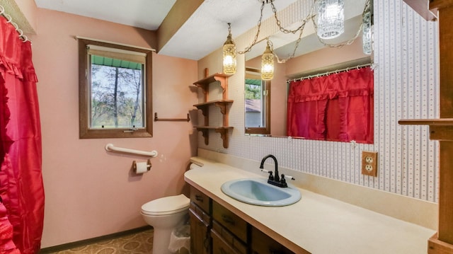 bathroom with toilet, baseboards, vanity, and curtained shower