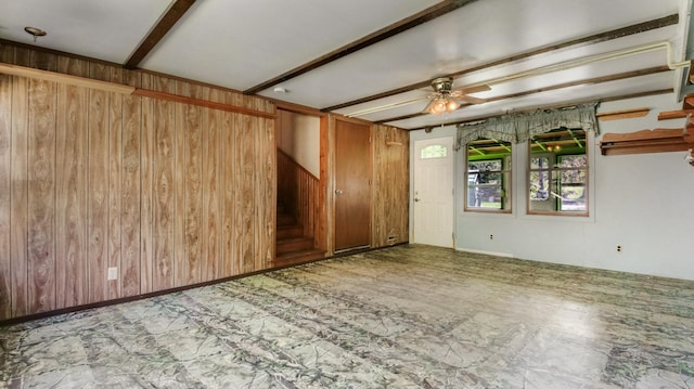 empty room with wooden walls and a ceiling fan