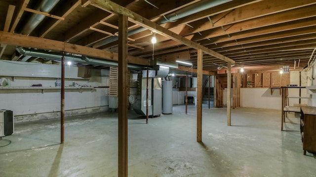 unfinished basement featuring gas water heater and heating unit