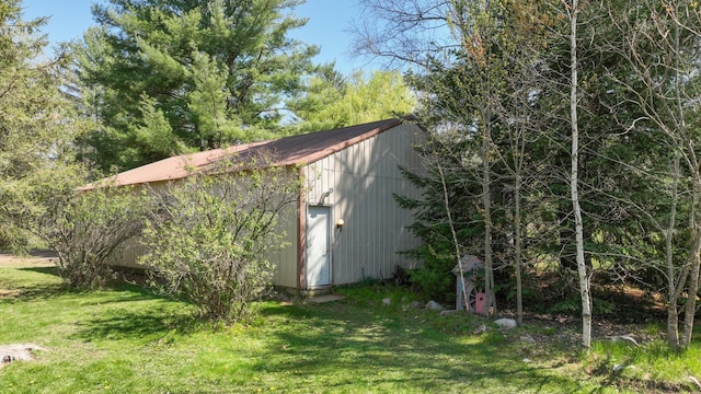 view of side of home with a yard and an outdoor structure