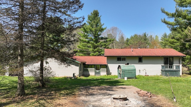 rear view of property with a yard and a sunroom