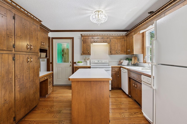 5235 139th St, Savage, MN 55378 - kitchen with white appliances, a chandelier, a kitchen island, light countertops, and ornamental molding