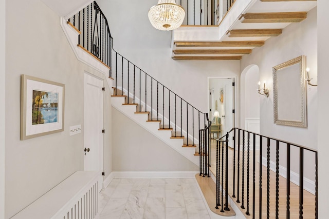 4201 Dupont Ave S, Minneapolis, MN 55409 - stairway with a chandelier, arched walkways, marble look tile flooring, and a towering ceiling