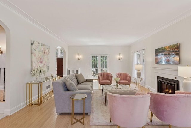 4201 Dupont Ave S, Minneapolis, MN 55409 - living area featuring arched walkways, light wood-style flooring, a glass covered fireplace, crown molding, and baseboards