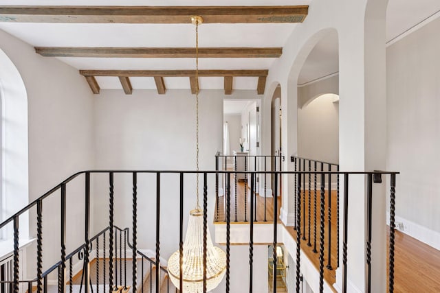 4201 Dupont Ave S, Minneapolis, MN 55409 - corridor featuring an upstairs landing, wood finished floors, beamed ceiling, baseboards, and arched walkways