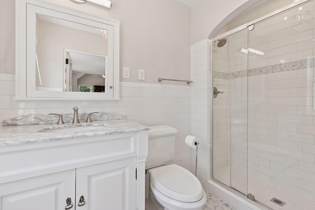 4201 Dupont Ave S, Minneapolis, MN 55409 - full bathroom featuring a shower stall, toilet, vanity, tile walls, and a wainscoted wall